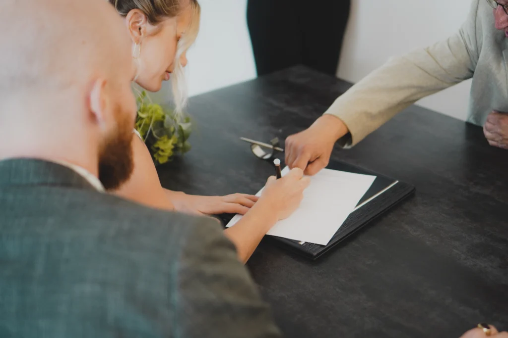 Australian couple signing home loan and finance documents at their desk